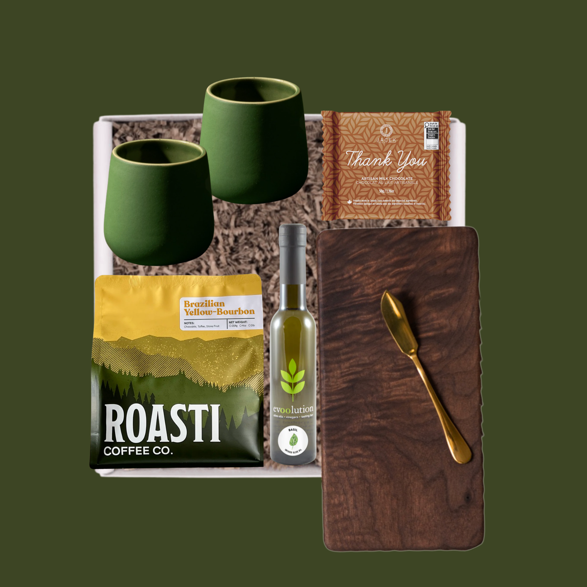 The Evergreen gift selection with a walnut board, green stoneware mugs, Roasti coffee, JACEK chocolate and Evoolution olive oil.