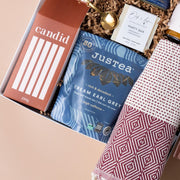 Close-up of Candid coffee, JusTea, honey, a gold spoon and a woven towel in the Call It Home gift.