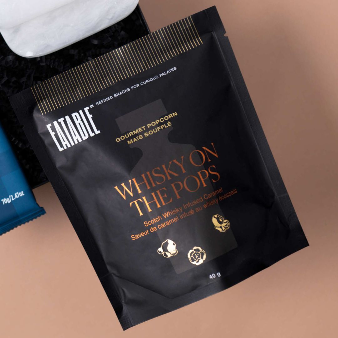 Eatable Whiskey on the Pops gourmet popcorn beside alabaster coasters.