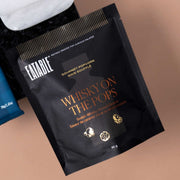 Eatable Whiskey on the Pops gourmet popcorn beside alabaster coasters.