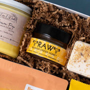Beaver Creek raw honey beside an Em & Oak candle and a lemon shower steamer.
